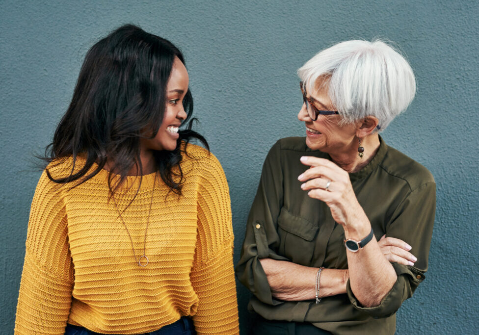 Senior businesswoman in conversation with younger female colleague