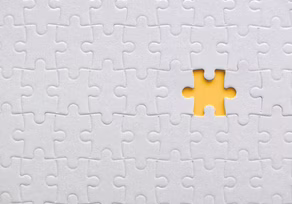 White puzzle with one yellow piece missing.