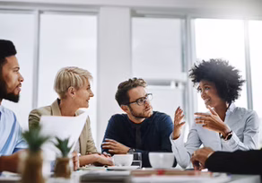 Three colleagues engaged in a lively discussion during a meeting.